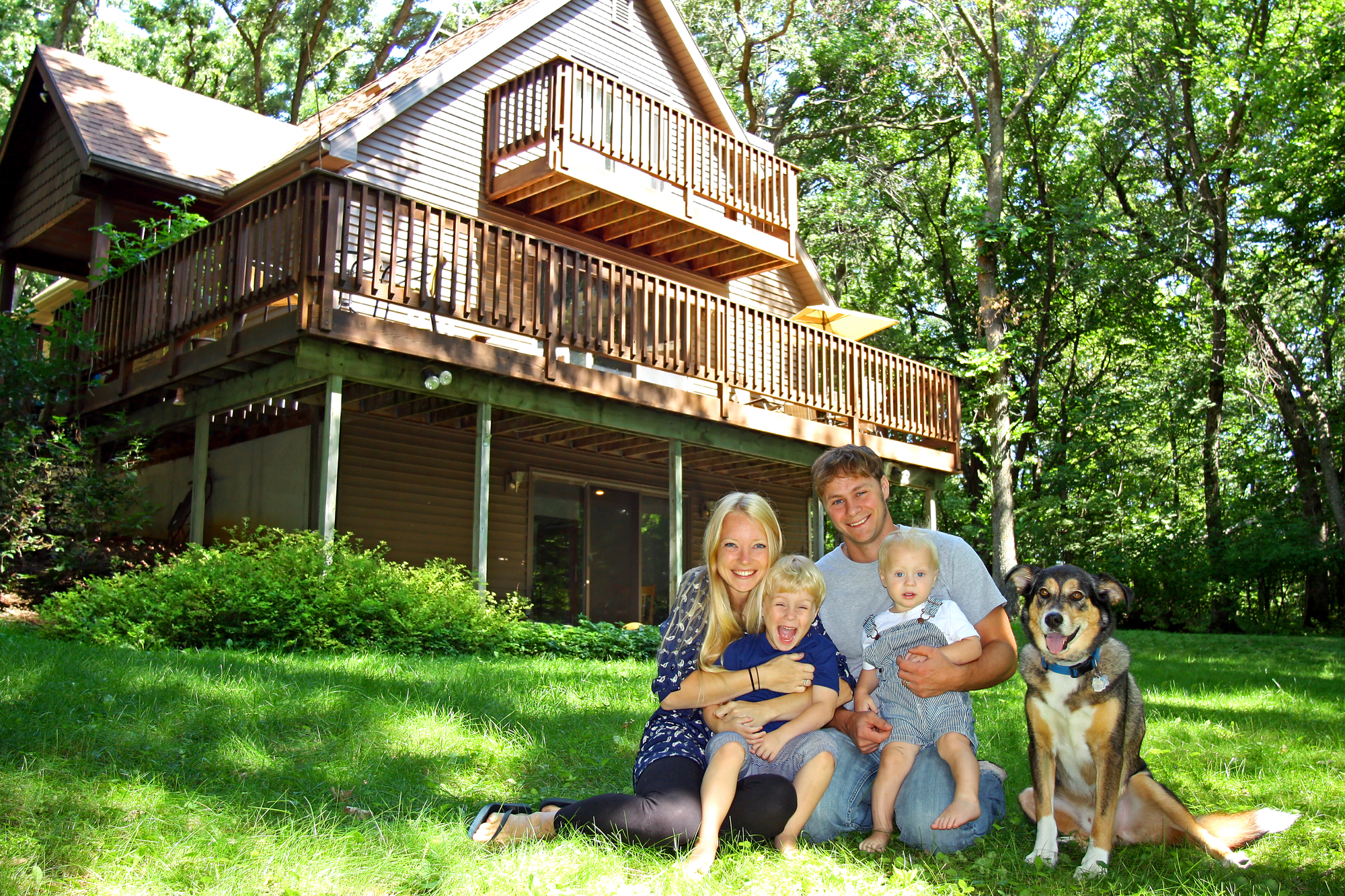 happy family of sitting infront of a cabin 