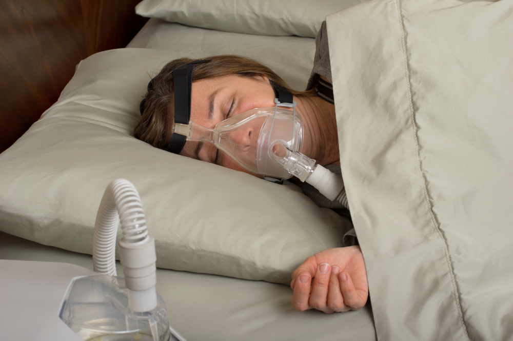 woman sleeping with CPAP machine on