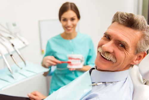 Elderly man on a review of a dentist, sitting in a chair